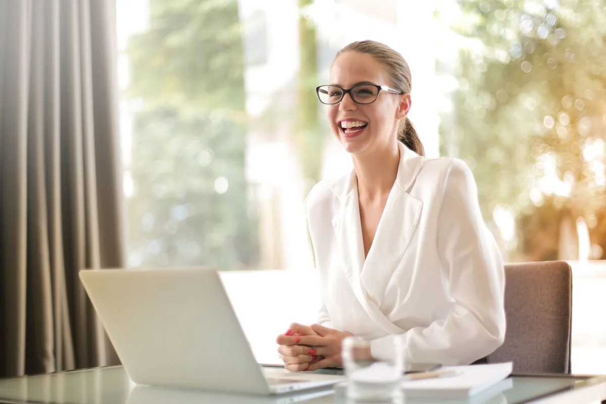 Digital Marketing Agency | ZenWeb Malaysia A business owner smiling while working on a laptop in a bright office