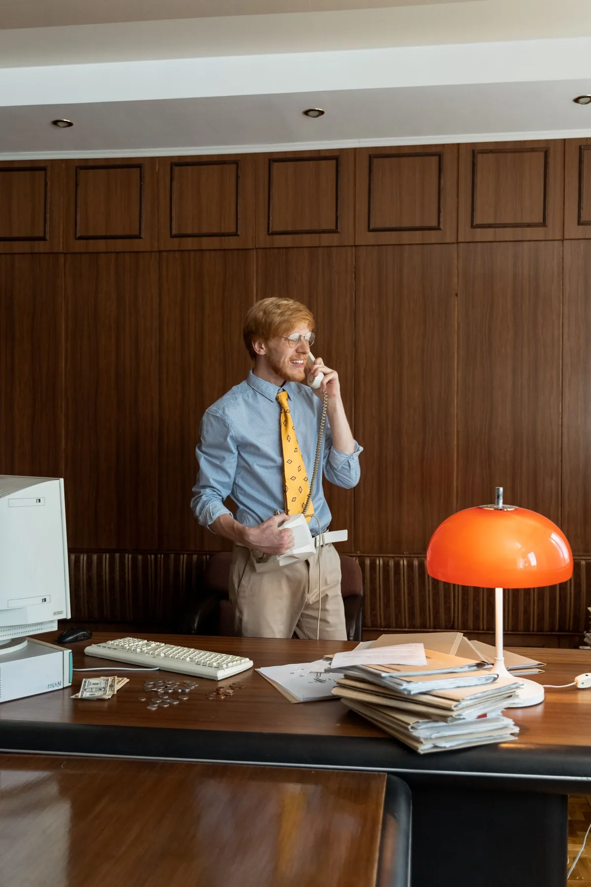 A business owner taking a phone enquiry at his office desk