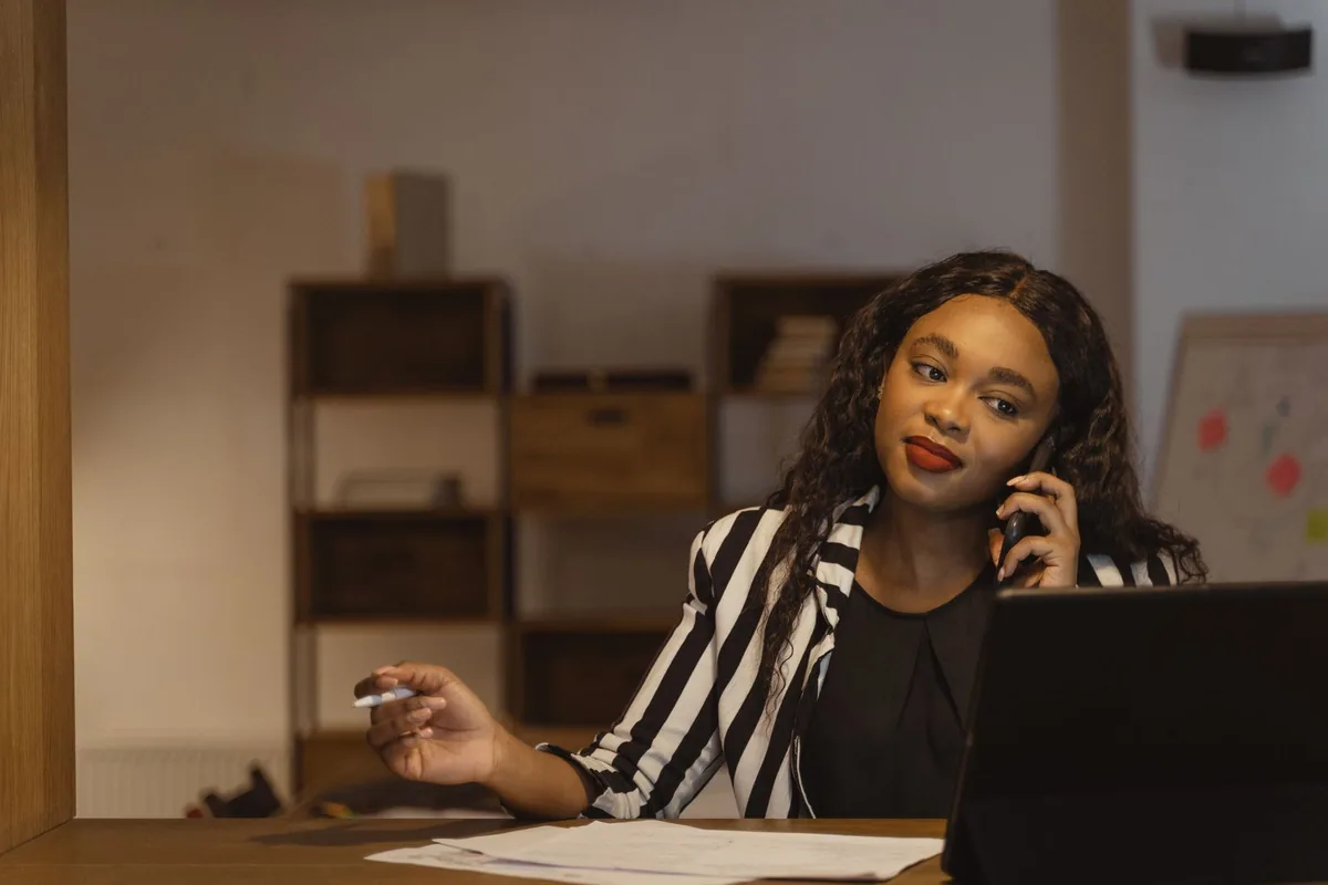 Digital Marketing Agency | ZenWeb Malaysia A businesswoman taking a phone call at her desk in a modern office
