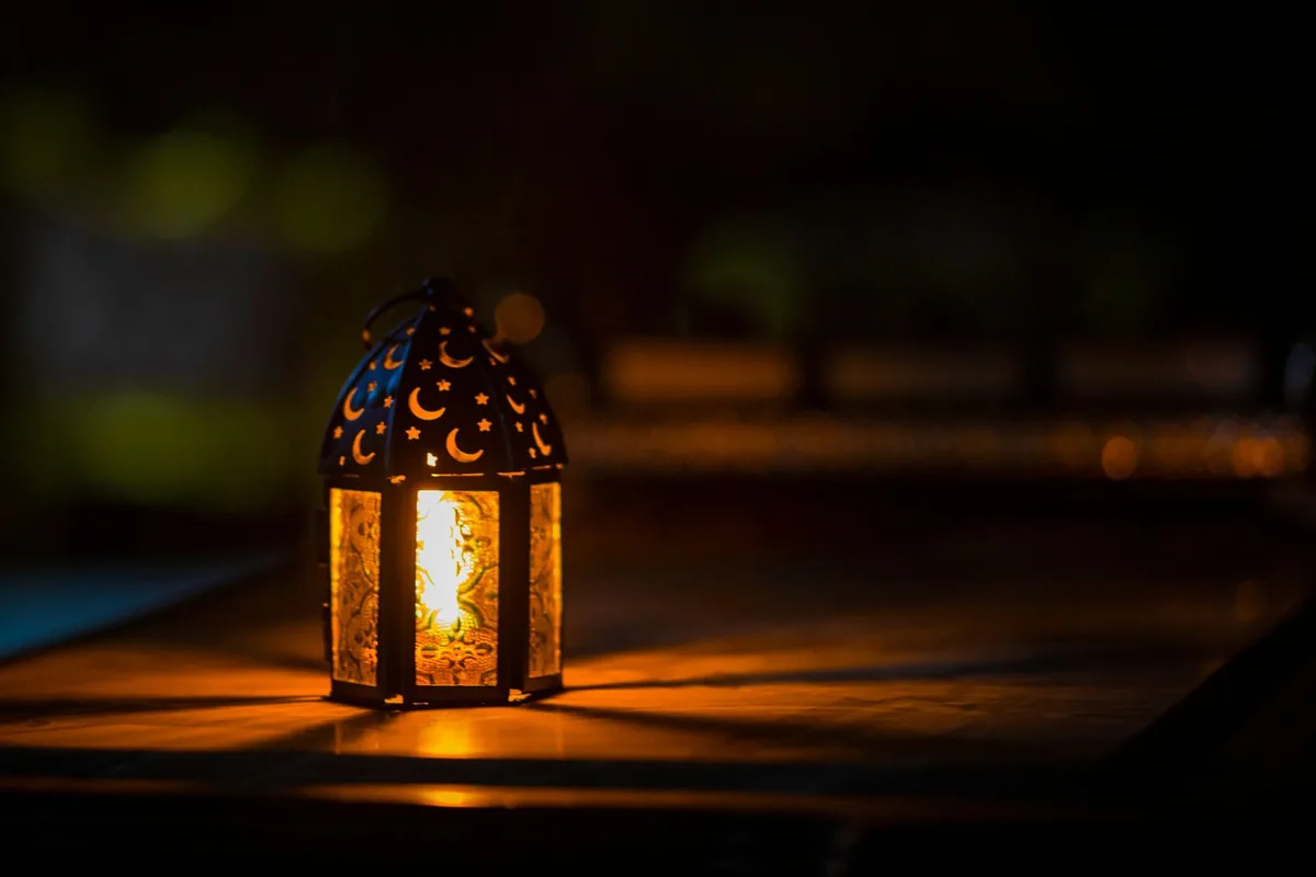 A festive Raya lantern glowing on a table