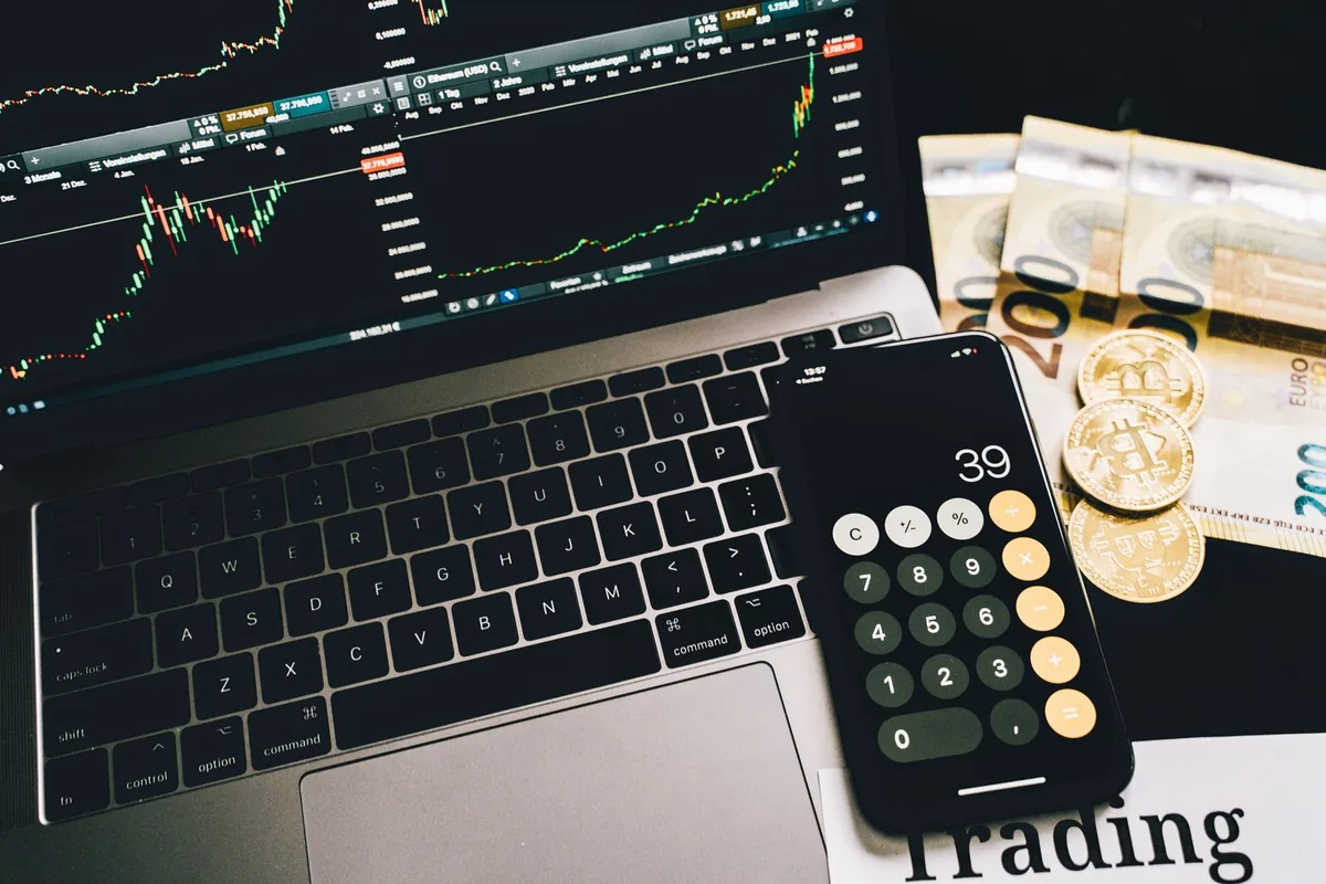 Digital Marketing Agency | ZenWeb Malaysia A laptop, calculator and cash on a desk while working out a project budget