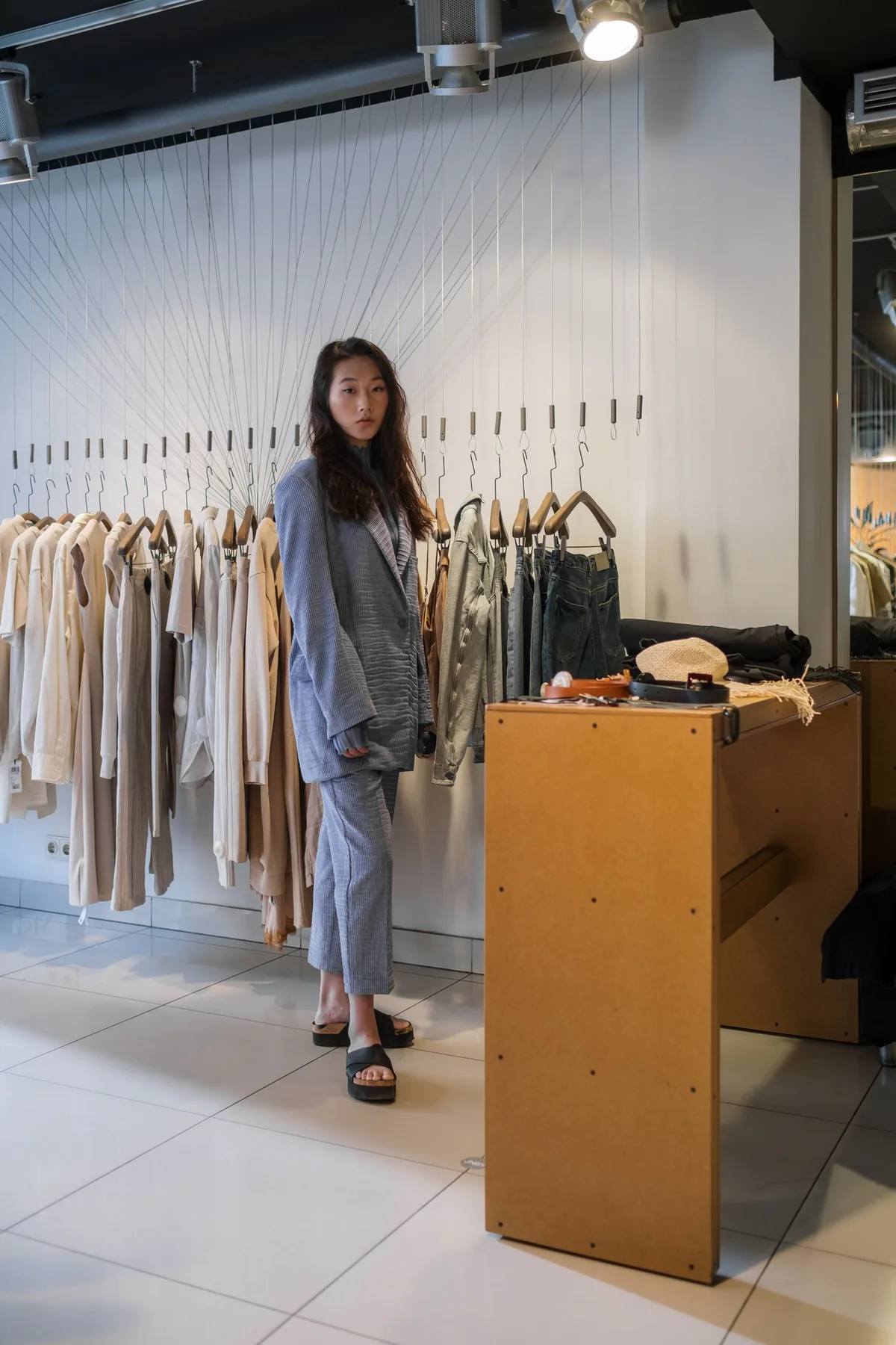 A shopper browsing clothing racks in a store before the festive season