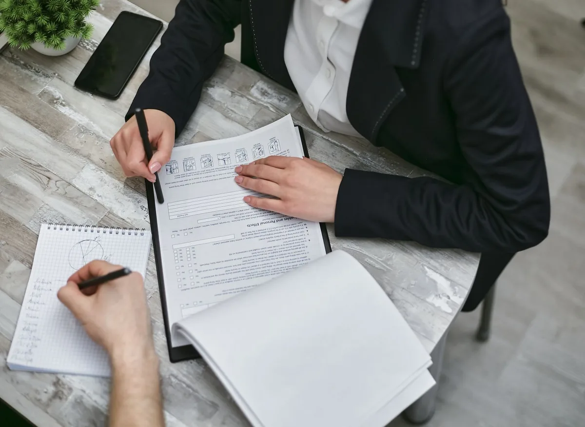 Digital Marketing Agency | ZenWeb Malaysia Two people reviewing a registration document across a desk