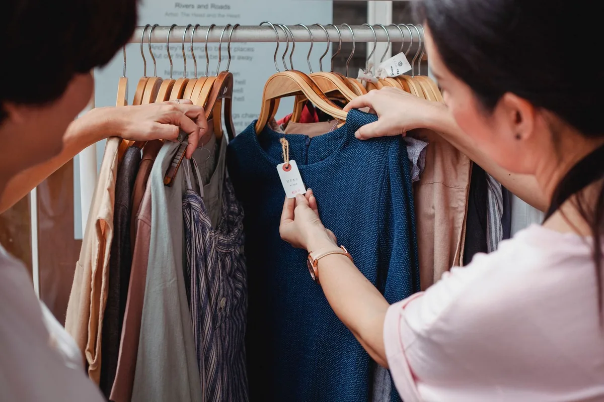 Two women choosing outfits together in a clothing store